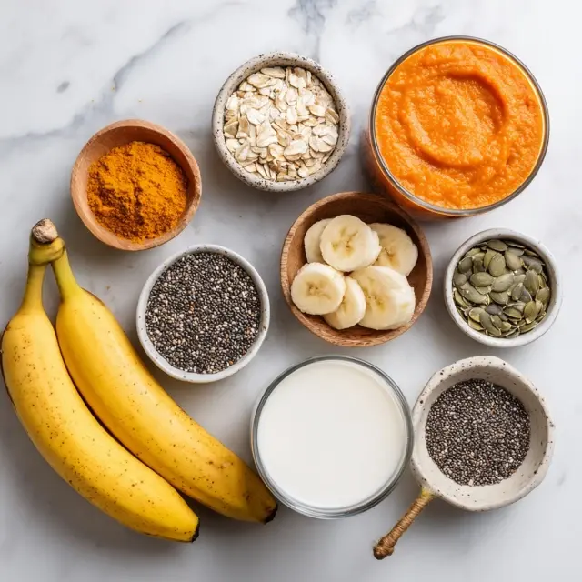 Ingredients for low sugar pumpkin banana smoothie arranged on a white countertop.